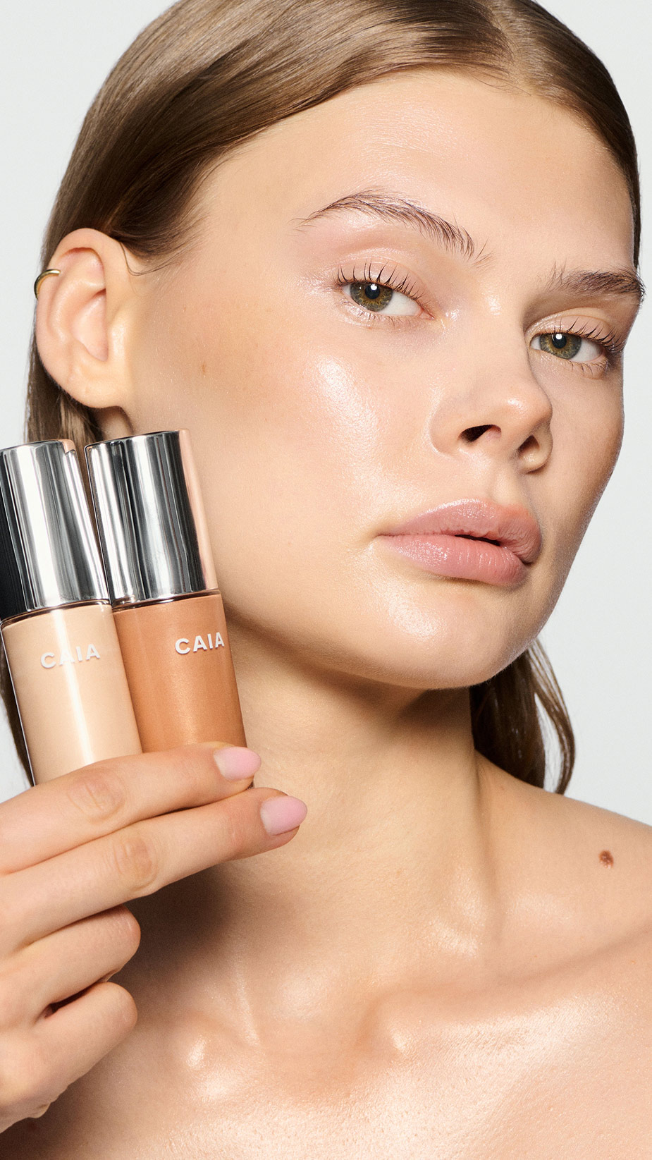 model holding Wake me up complexion enhancer in two shades