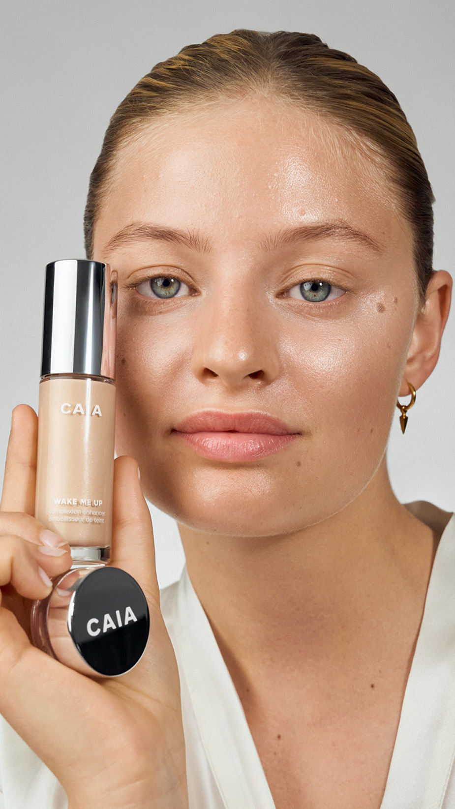 model holding Wake me up complexion enhancer in two shades